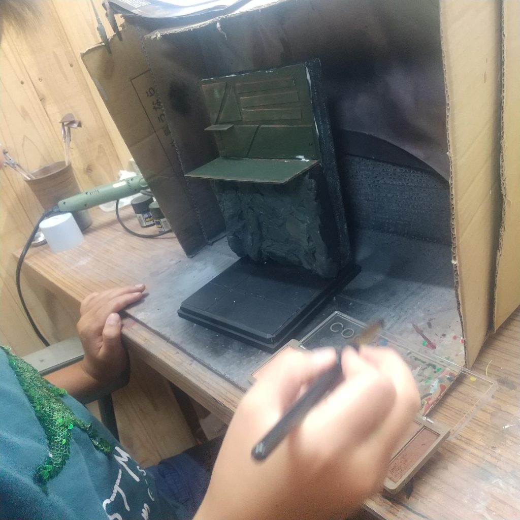 木工用ボンドで張り付けて、その後にアイシャドーで汚しを入れ、艶消しクリアーをふり、ガンダムを置いたら完成!!