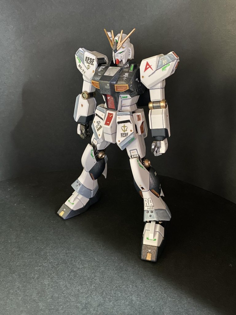 実は組んだ当時はあまり好きでは無かったhgucνガンダムのスタイル。劇中では全長22mと、すでに18m級MSの時代からは等身ひとつ大きくなっている設定が有り、それを忠実に再現してあるんですが、gジェネで初めてνガンダムを知った自分としては、全てのMSが同じ等身の様な感覚で居たので、どうしても全体が間伸びした様な印象がしたんだと思います。(サザビーなどは横幅や全体のボリュームも有るので気にならなかった)今回は、密度感を上げて、その間伸びした印象を解消する事をテーマとしました。先に貼ってあったデカールはなるべく生かしたかったので、黒部分はメタリックの入ったクリヤーコートで粒子感を出し、白部分は成形色生かしのつや消し仕上げ。パネルラインの一部にRGを参考にライトグレーを入れました。