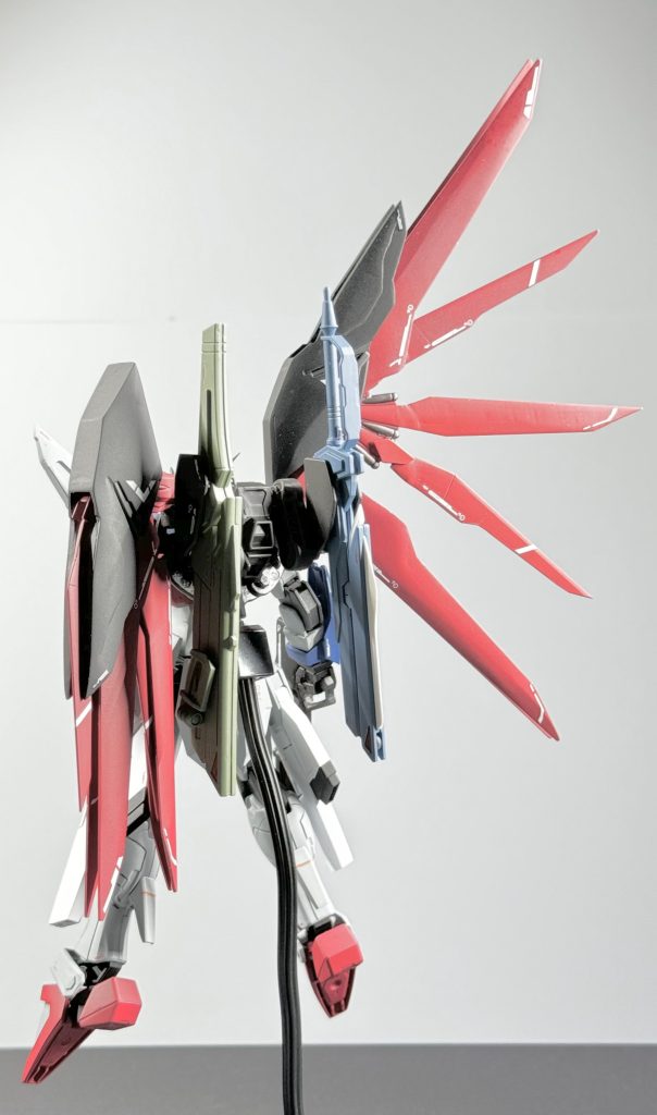 以下各部改修内容です。【頭部】ライジングフリーダムの頭にHGCEデスティニートサカ、頬を移植、マスクは旧HGデスティニーの物にプラ板で鼻筋を盛ってみました。↑個人的には1番頑張ってやったつもりです!イケメンマスク大事!【胴体】ライジングフリーダムの胴体をパテプラ板にて形状変更、コックピットの周りはデスティニーの形状に寄せてみました。【肩】ライジングフリーダムの肩にHGCEデスティニーのフラッシュエッジを脱着出来るよう加工して取り付けHGCEデスティニーの肩も切って貼っています。【腕】HGCEフリーダムの腕にライジングフリーダムのパーツを取り付け、フレームもHGCEフリーダムとライジングフリーダムをニコイチで混ぜています。【腰】ライジングフリーダムの腰パーツにHGCEデスティニーのフロントスカートを加工して取り付け、サイドスカートはHGCEデスティニーの物をぶった切ってレールガンに接着、レールガンの部分はHGCEフリーダムをベースにライジングフリーダムのレールガン主砲を取り付けてみました。【脚部】足首のアーマー以外はHGCEフリーダムの脚をそのまま使っています。基本はプラ板での形状変更とディティールアップです。また、内部フレームと外装をプラ板で延長加工をしています。【バックパック】HGCEデスティニーのバックパックと羽をベースにライジングフリーダムとフリーダムのパーツを使って混ぜていきました。デスティニーの羽の黒いカバーの様なパーツはHGCEフリーダムの羽の基部にある菱形の排気口のパーツを可能な限り薄くして取り付け、プラ板で形状変更をしました。また、羽を広げた際に一枚一枚が均等に広げられる様一部ボールジョイントを仕込んでいます。オリジナルデカールも貼っていたりしますが、ちょっと色味が薄くて見にくくなってしまいました。