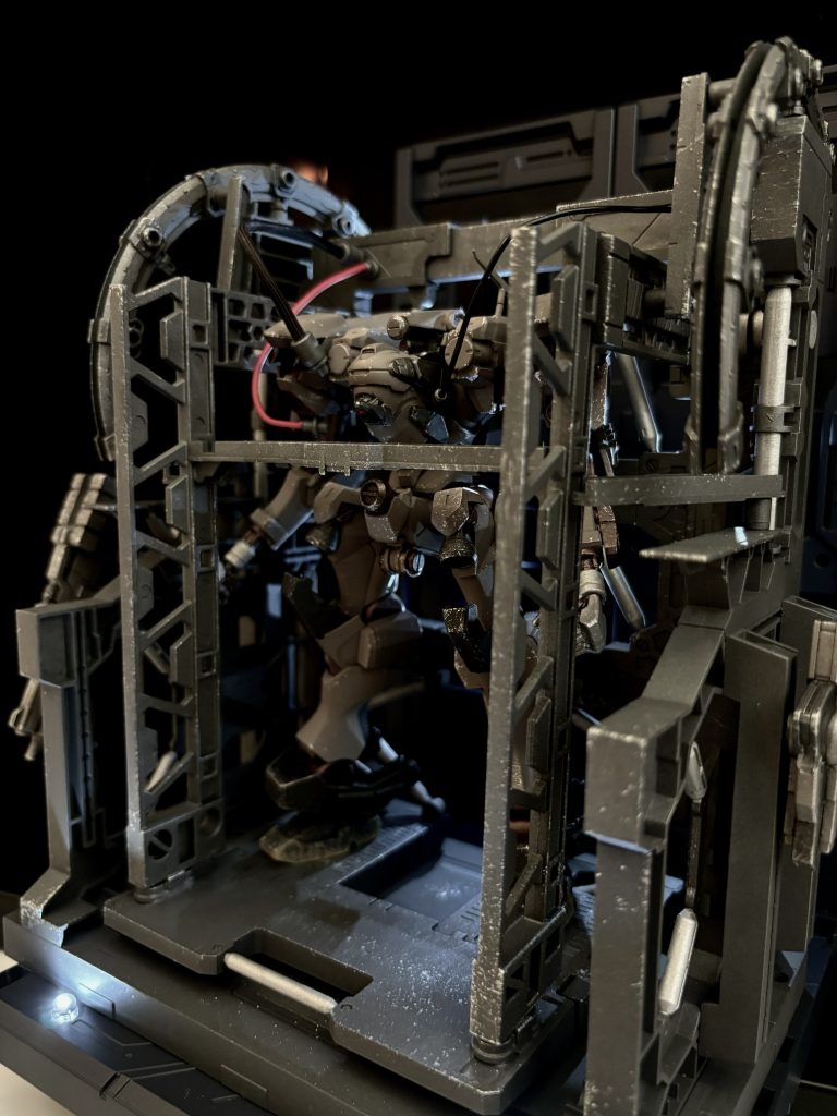 [ハンガー]プレイ中幾度も見ることになるハンガー。お気に入りの愛機を眺めて何度も満足げなため息をついた方も多いことでしょう。せっかくACをつくるなら…！と今回はAC6のハンガーをイメージした台座も制作しています。 