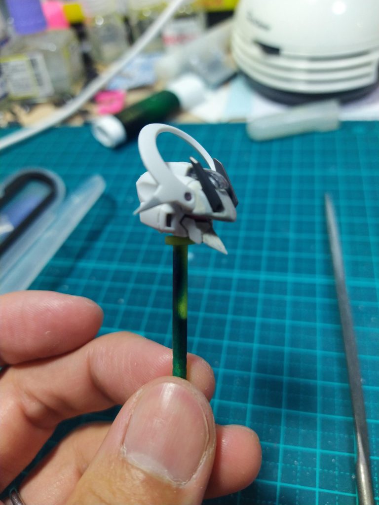 顔を色々いじっているところ。目は一文字につなげてます。サイバーなサムライといえばこう！あとは口元を伸ばしてガンダムMkVっぽく。ほかには額のバイザー部分をパテで延長、それに合わせて額のパーメットが光る部分も形状変更。ツノも少し形を変えて後ろに流す形にしました。他には後頭部も庇の延長に合わせて削り込んでエッジを作ったのと、頭の輪っかの角部分を成形。