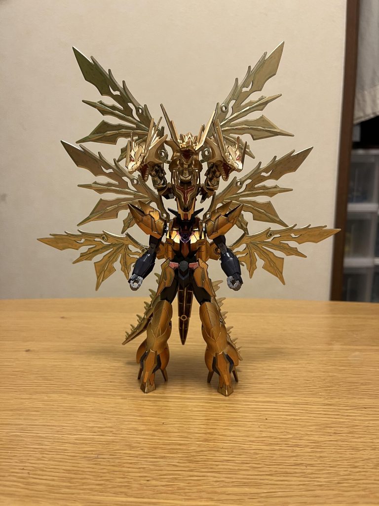 機体名:ガンダムネオタキオン全高:34.5m重量:107.45tガンダムタキオンの進化形態にして、超強化型として本来の力を解放した真の姿でもある。全身金色のカラーリング、キングギドラのような3つ首の頭部ユニットが特徴。略称は、ネオタキオン。パイロットは、引き続きミザエル(CV:大河元気)。男性。コーディネーター。年齢は、14歳。リベンジャーズの幹部の1人であり、詳しくはこちらを参照。