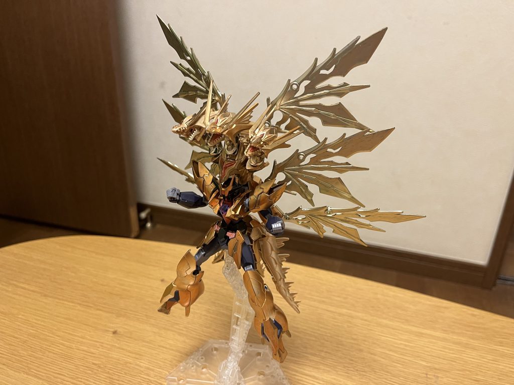 特殊能力いずれも、超強化型のDGハイパワーエンジンの力によって会得した能力である。時間逆行能力「タイムタイラント」周囲を強制的に時間逆行させる特殊能力であり、進化前の「タキオントランスミグレイション」の強化版。基本的に進化前と同じ「対象を指定せずに周囲を巻き戻す」時間逆行だが、有効範囲は半径100km(進化前の5倍以上)に膨れ上がり、しかも有効範囲の調整が可能となっている。さらに「本機のパイロットが許可しない限り、発動後から120分間は、本機以外の有効範囲内にいる存在は、特殊能力・特殊機能を使用不可能になる」という恐ろしい封殺効果まで追加されており、MSや戦艦が主に戦闘で使うミラージュコロイドやゲシュマイディッヒ・パンツァーなどの特殊機能が使えなくなる他、DG細胞やアルティメット細胞を用いた特殊能力に関しても、MSだけでなくパイロット自身も使用不可能となる。さらには「影響の対象外を指定する」をも可能としており、無差別ではなく敵機のみを無効化出来るようになる等、使い勝手が良くなっている。ただし、引き続き進化前と同じく「体感時間を操作する」だけなので、人間の精神や記憶には干渉しない他、特殊能力への耐性を持つMSや細胞の力自体が強すぎて能力や機能を無効化できないMS、本機と同じ時間操作系の特殊能力を持つMSには通じない。そして、この能力の発動には莫大なエネルギー消費が必要となる為、再度発動には1時間のチャージを要する(進化前の5倍に相当するが、有効範囲を狭めた場合は多少短縮される)。そして、この能力のもう一つの恐ろしい特徴は、事実上の死者蘇生でさえ可能とする点にある。MSの損傷や撃破、パイロットの負傷から戦死などは、この能力を用いて時間を巻き戻す事で、それらの事実を「無かったこと」にできる。この芸当は、進化前はおろか同じ時間操作系の特殊能力にも不可能であり、本形態のみが可能とする極めて稀なもの。また、特殊能力への耐性を持つMSや時間操作系の特殊能力を持つMSに対しても、仮に撃破・戦死していた場合に限り、それらを撃破される前の状態に戻す事が可能(これは、死者には特殊能力への耐性が無く、巻き戻しによる蘇生によって、その耐性も復活するため)。時間操作耐性上記の時間逆行能力の使用だけでなく、その暴発防止の関係上、本機は時間操作系の特殊能力への耐性を持っており、本機とパイロットはそれらの影響を一切受けない。