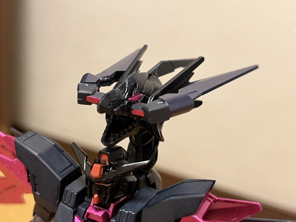 武装本機の攻撃手段は少なく、タキオンクローとタキオンドラゴンユニットのみであり、それ以外の攻撃は徒手空拳に限られる。タキオンクロー×2本機の固定装備であり、両腕のマニピュレータから発振する接近戦用のビーム兵器。それぞれの指からビーム刃を発振させ、そのまま手刀の形に合わせ収束させる事で、ビームサーベルとして形成する。もっぱら後述のタキオンドラゴンユニットを主兵装とするが、こちらも攻撃力が高く、ナノラミネートアーマーを持つMSを軽々と斬り刻む。タキオンドラゴンユニット×1本機のメイン武装であり、本機の特徴であるキングギドラのような3つ首の頭部ユニット。その口から放つ咆哮は、凄まじい衝撃波が伴い、一般的なMS複数機をまとめて吹き飛ばすほどで、さらに鋭い牙は、PS装甲を持つMSですら物理的に噛み砕く攻撃力を有する。必殺技タキオン・フレアスパイラルタキオンドラゴンユニットから、紫色の竜巻のような破壊光線を放つ。FT装甲をも遠距離から粉砕する凄まじい威力を誇る。