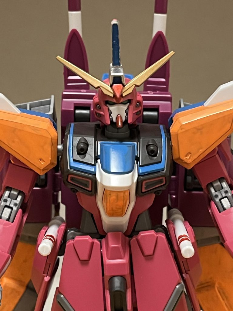 機体名:インフィニットジャスティスガンダムリバイブ全高:18.90m重量:84.67tインフィニットジャスティスガンダムがDG細胞に感染した事で、変貌を遂げた強化形態。略称は、ジャスティスR。パイロットは、アスラン・ザラ。※ただし、IF版になります。外観従来のピンクを基調としたカラーリングはそのままに、腹部にはオレンジが、胸部には水色が、それぞれ追加されている。頭部にも、ゴールドとシルバーのカラーリングが追加されている。そして両肩は、オレンジと水色のカラーリングが表裏で成されている。基本性能DG細胞の力を受けて、基本性能が大幅に強化されている。動力源引き続きハイパーデュートリオンエンジンが搭載されているが、DG細胞の力でエネルギー生産量が大幅に強化されている。機動力・スピード従来通り単独飛行も可能だが、その真価は後述する疾風モードで発揮される。防御力・耐久性装甲には、VPS装甲を採用しており、関節部は銀色に発光する。本機の場合、フレーム部はフェイズシフト装甲材で構成され、対弾性が向上、近接戦における激しい動きにも耐えうる剛性も獲得しているが、こちらではストライクフリーダムのような細かい装甲分割機構は採用されておらず、腕部・脚部のスライド式装甲の採用に留まっている。こちらもDG細胞の力を受けて、装甲強度が高まっているが、その真価は後述する剛烈モードで発揮される。攻撃能力従来では不可能だった武器を用いない徒手空拳が可能となっているものの、ハーデスインパルスガンダム黄泉冥王には遠く及ばず、その真価は後述する剛烈モードで発揮される。ドーピング機能DG細胞を利用したドーピングが可能になっており、パイロットの肉体にDG細胞が浸透させ、痛覚を鈍らせつつ、反応速度を引き上げる事により、負担とダメージを限界まで無視して、戦闘を続行する事が可能。しかし、このドーピングは、肉体のみならず、脳にもDG細胞が浸透する為、精神を好戦的な気質に変化させる危険性がある。そして、長時間使用を続ければ、自我と精神の崩壊を招くだけでなく、最悪の場合は死に至る。特に、パイロット自身のDG細胞の適合率と精神力の低さに比例して、DG細胞の脳への浸透濃度が高まっていくのだが、肝心のパイロットのアスラン・ザラは、適合率が低く、しかも優柔不断な性格な事もあり、相性の悪いシステムである。