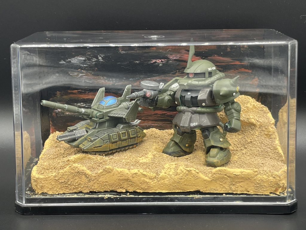 これがしたかったんだよ～！②　マイクロウォーズでも再現しちゃいました。ケースは１００円ショップで買ったものにアクリル絵の具で背景をそれっぽくかきかき。マイクロウォーズ、ちっちゃくて可愛くて好きなシリーズでしたが、いつの間にか終わっちゃいました。マイナーメカの立体化も嬉しかったのに。あと、ボトムズも好きなので、パイロットの乗り込み方も好きでしたね。むせる。　今はその役割をモビリティ・ジョイントに引き継いだ感じでしょうか。モビリティ・ジョイントも好きでいくつか集めているので、また紹介したいと思います。