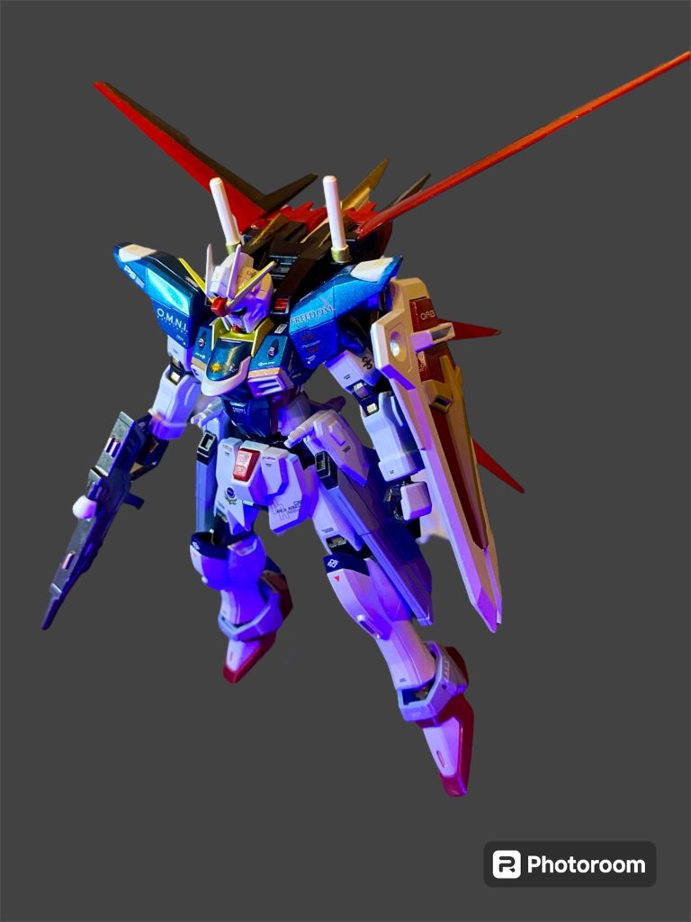 前回に引き続き、SEEDコンに合わせた過去作供養です。2023年正月に制作したHGCEフリーダム。その頃はもとのフリーダムのカラーリングがあまり好きになれないお年頃だったので、エールストライクやら、初代78、以降連綿と続いてきた定番のトリコロールを参考に色変え全塗装で仕上げていました。メインカラーにしたのは水性ホビーの青竹色ですが、綺麗なメタリックブルーです。アンテナの内外の色は反対に(オリジナルは内が金、外が白)、スリッパは赤(オリジナルは青)、ライフルはガンメタ(オリジナルは白のカバーに青のライン)など、カラーリングで“フリーダムじゃない感”を目指していた頃でした。一応デカールを貼ってありましたが、今回撮影前にさらにデカールワークを追加しています。EG版エールストライカー武器セットの2軸互換パーツを使うことで、無改造でストライカーパックも背負わせられる様になったので、組み替えてみたら、まぁカラーリングもあってかよく似合うwストライクとインパルスの間に居そうなガンダムです(gandam1)