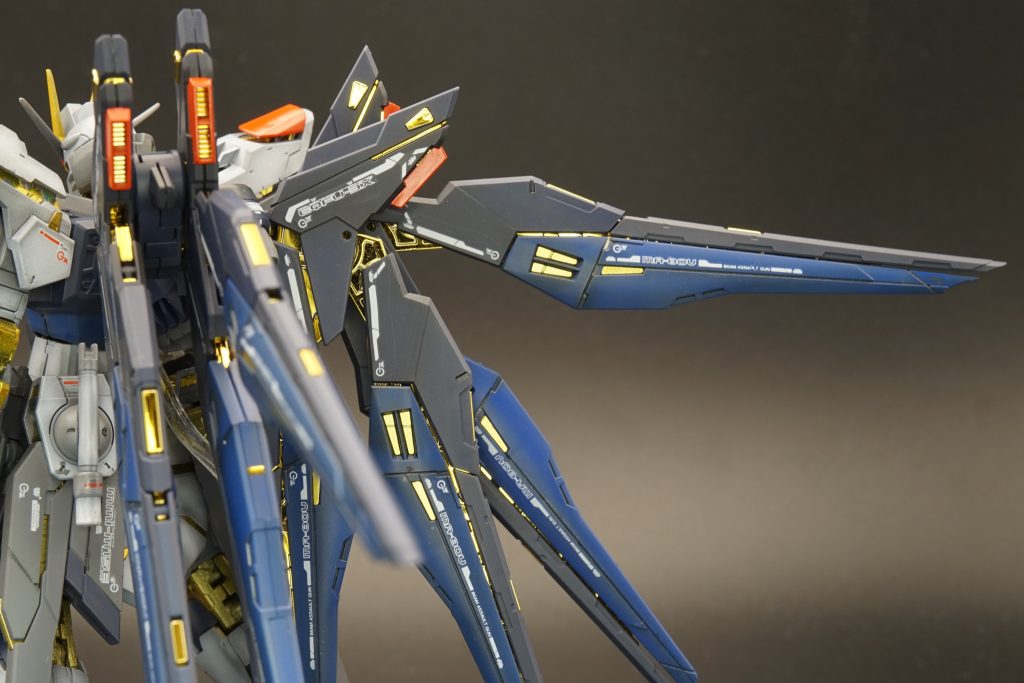 背負い物、巨大です。この羽根の金メッキフレームに近づくように、本体内部フレームを頑張って塗装しました。ツヤも出るように、クリア系をメインに塗り重ねています。もちろん下地にはガイア マルチプライマーを吹いて割れ防止をしています。青色の部分の色分けは下地色の濃淡の後、コバルトブルーで塗り分け。