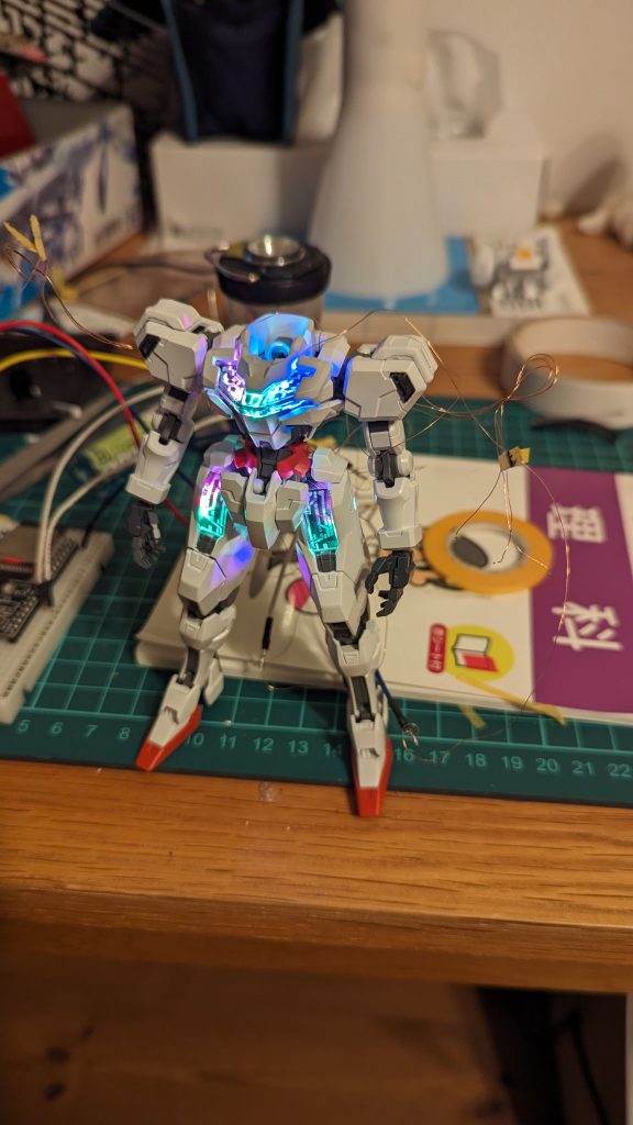 LEDを設置している途中の図胸部には4つ、脚部には3つずつLEDが付けられています。後につけるものもそうですが、全て並列接続で、電源供給はESP32から行われています。(3.3V) ちゃんと抵抗とか定電流ダイオードを挟むべきなのでしょうが、知識が足りずできませんでした。まだこの頃は色の調整をしておらず、ちゃんと1677万色に光っていました。ESP32はArduinoと同じ言語で動かせます。このプログラミングはChat-GPTの力を借りて行いました。この後のWi-Fi操作のためのプログラムもそうやって作っています。