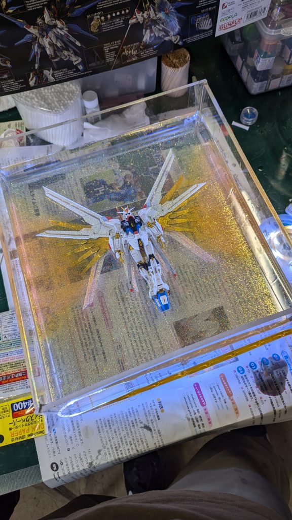 最終層まで注型が完了した図黄色いモヤモヤはガイアノーツのスターブライトゴールドを混ぜたレジンを使って作っています。周りにあるナノ粒子はダイソーのネイルラメを使用して表現しています。