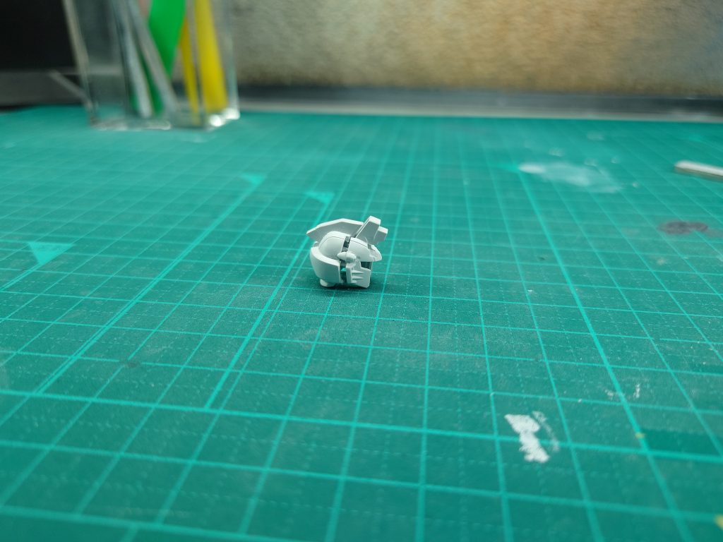 ◎頭部の合わせ目消し頭部の合わせ目消しに初挑戦しました(画像はやすり掛け前)。ホビージャパンの作例を参考に頭部バルカン砲だけ切り落として、前側に接着する方法で処置。文章にするとたったそれだけですが、きれいに切り落とすのも、形状出すのも大変でした…!経験が必要ですね設定画的には上側の合わせ目も消すべきですが、今回は端部を削ってモールドっぽくしています。