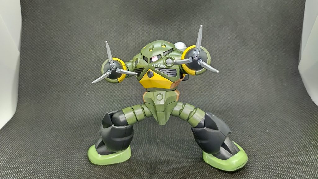 そんな折、シミズ港に近いオオハマ海岸で擱座したズゴックが発見される。これを聞きつけたショップの常連が、いつの間にか機体を入手。実はこの地域はMSの開発·建造·整備を担う、知る人ぞ知る隠れた一大拠点であり、ショップの客たちも大半がMS技術者や関連企業の人間だったのだ。