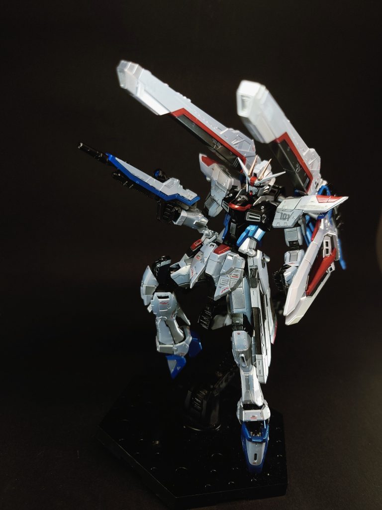 M100 バラエーナプラズマ収束ビーム砲×2[注 37][注 3][注 38]本機の武装中、最大の射程と破壊力をもつ大口径・大出力ビーム砲[43]。戦艦並みといわれるその破壊力は[60]カラミティの「125mm2連装高エネルギー長射程ビーム砲 シュラーク」を上回り[40]、1門でランチャーストライクの「320mm超高インパルス砲 アグニ」に匹敵するとされる[14]。核エンジンの搭載決定に伴い追加が可能となった兵装のなかで、開発陣が真っ先に採用しようとした武装。2発の発射でゲイツ改が停止するほどの電力消費量の問題で事実上の失敗作の烙印を押されていたが、核エンジン搭載による再度の発射試験で改めて威力を証明され、一度は搭載許可を取り付けた。しかし、当時のMS設計局と武装機器の設計局は反目しあっており、MS本体の設計局から「その砲身の大きさが原因となり機体全体のバランスが崩れるのではないか」という意見も上がったが、機械工学の権威でもあったユーリ・アマルフィは「姿勢制御用の能動性空力弾性翼に、挟み込む形で砲身を保持させる」という案を持って仲裁を行い、MSの頂点ともいえる本武装の採用が実現された[68]。