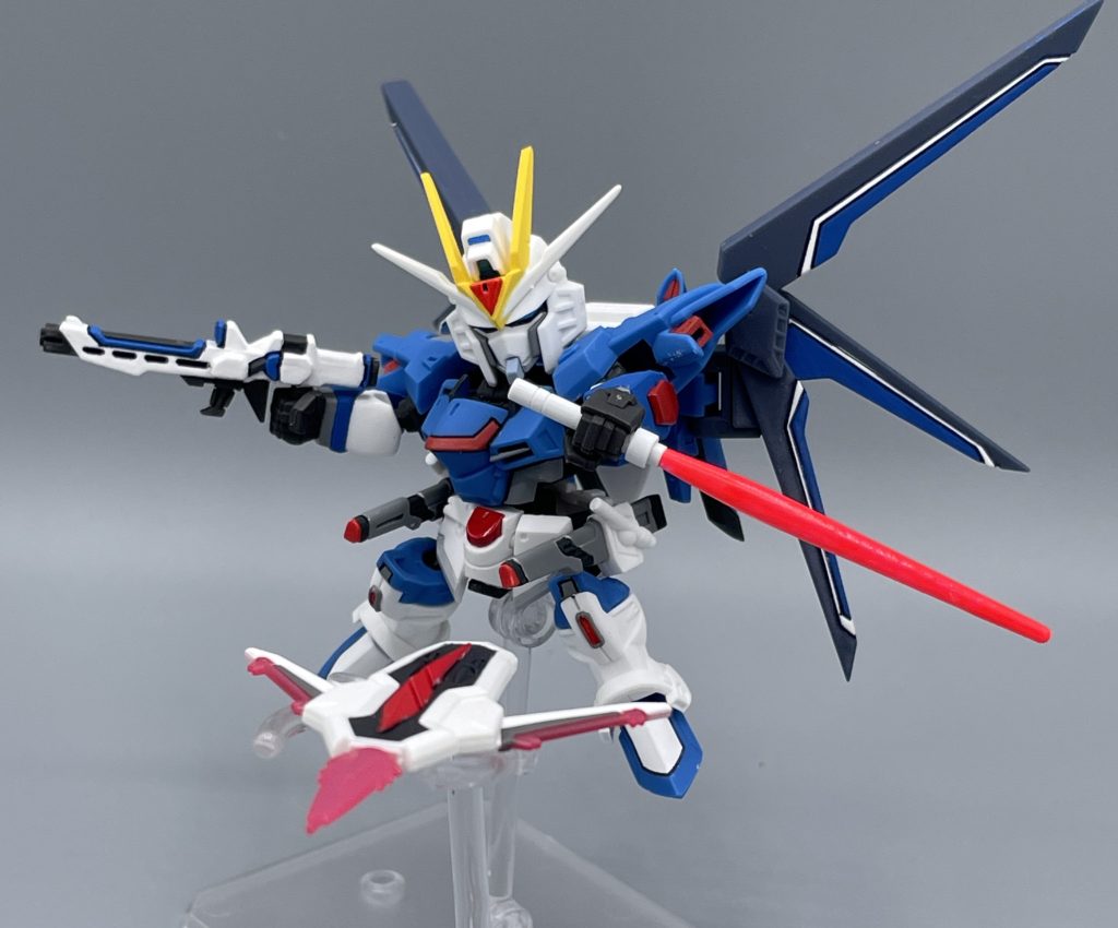 RQM73フラッシュエッジG-3シールドブーメラン 画像のビームを展開したシールドは、キットには付属しません。このシールドは2024年7月下旬に発売されたモビルスーツ・アンサンブルに収録されているものです。MJ自体は嬉しくてすぐに作ったのですが、そのままずっとお部屋に飾られていました。なぜなら、この写真が撮りたくて、アンサンブルの発売をずーっと首を長くして待っていたからです(笑) そして、画像で展開しているウイングがライフリ用EXパーツに付属する物なのですが・・・。なんか違うくねぇ??・・・ そうです、MJ独自のアレンジでまさかの3枚羽仕様。かつアグニ砲はオミットという大暴挙です。食玩であり、価格も価格なので、「ハイマットフルバーストを再現せよ」などと申し上げる気はあるませんが、これはちょっと看過できない点かなと思います。 仮にもEXパーツなんですから、ここは省略しちゃいけないポイントじゃないでしょうか。昨今の物価上昇や製作コストの調整で仕方ない部分も理解していますし、“たられば”を言うのは簡単です。しかし、素人目に見ても、“他にやりよう” が感じられるほど、残念な仕様です。 例えば、EXパーツの大型ライフル&シールドのコストを羽の分割に回すだけでも、羽を分割させられそうな気がします。実際のことは分かりませんが。