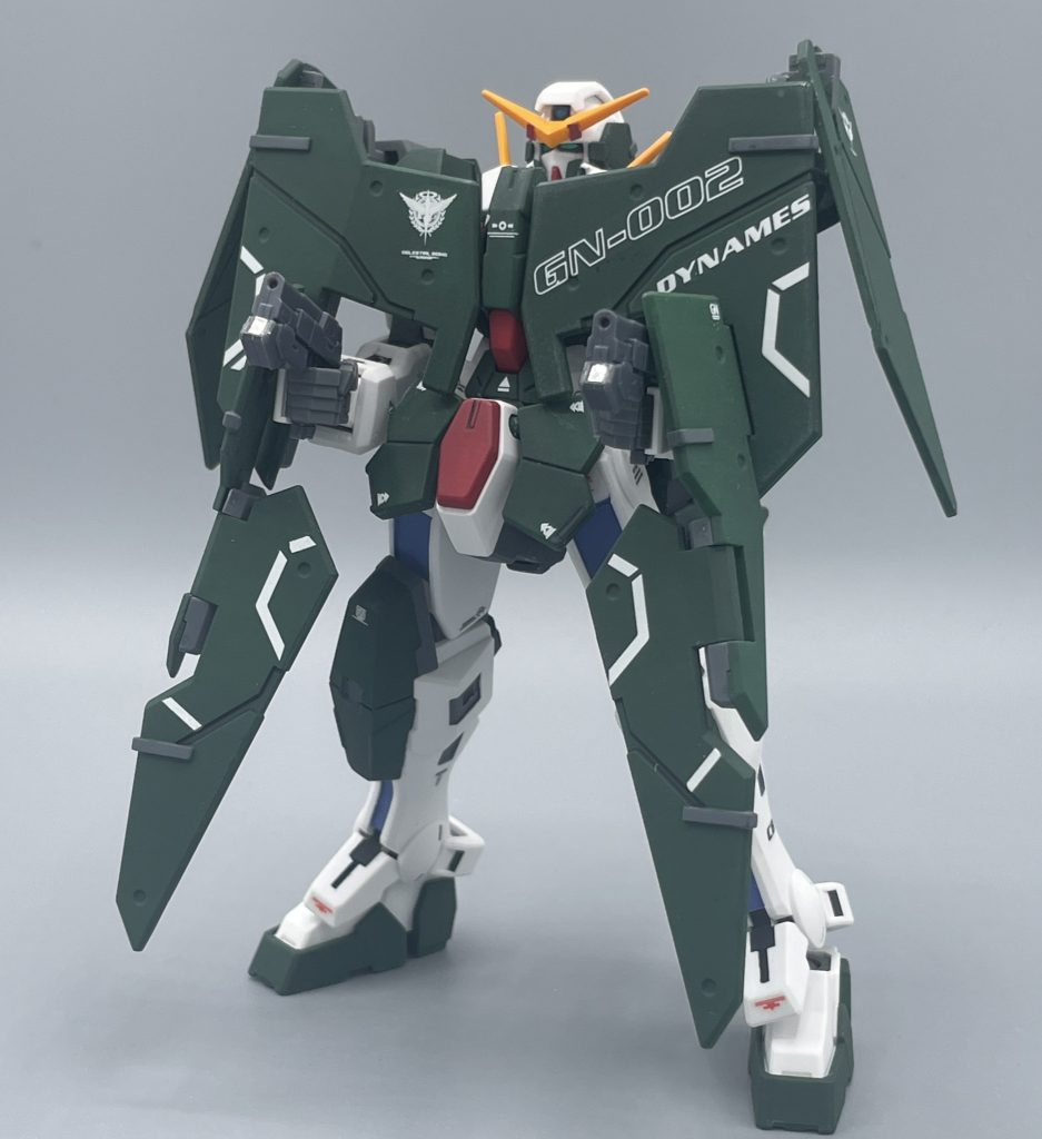 GNビームピストルで攻撃。シールドの隙間から、ピストルを展開させることも勿論可能です。やっぱり、絶対にピストルを付けなきゃいけないキットでしょうよ。 GNピストルの活躍で特に印象的だったのは、個人的には「合同軍事演習を謳ったガンダム鹵獲作戦」のシーン。 ユニオン軍のオーバーフラッグス隊の編成に伴い、アラスカから異動してきた、ジョシュア・エドワーズというエースパイロットがいました。 オーバーフラッグは、ユニオンの威信をかけて作られた傑作機ですが、”空中変形”は隊長のグラハム・エイカーしか出来ないスゴ技で「グラハムスペシャル」の異名で呼ばれた彼の専売特許でした。 しかし、功名心が高くアラスカでエースと呼ばれたジョシュアは、ガンダム鹵獲作戦で、この空中変形を披露して隊員たちを大いに驚かせます。そして勢いそのままに、マイスターズが塹壕として利用していた渓谷へと迂闊にもダイブ!!しかし・・・ ドンピシャの位置で待ち構えていたのが、ガンダムデュナメス。最小限のモーションで、一瞬のうちにGNビームピストルで打ち抜かれました。 オーバーフラッグス隊にフォーカスが当たっていたシーンだった故に、“敵から見たガンダムの恐ろしさ”を演出する名シーンだったと思います。←GNビームピストルめっちゃ大好きマン(笑)