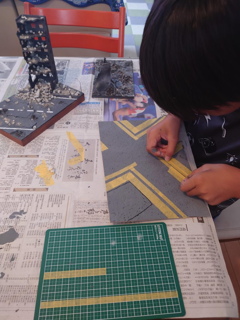 コルクシートにグレーを塗って白線を塗る為にマスキング中