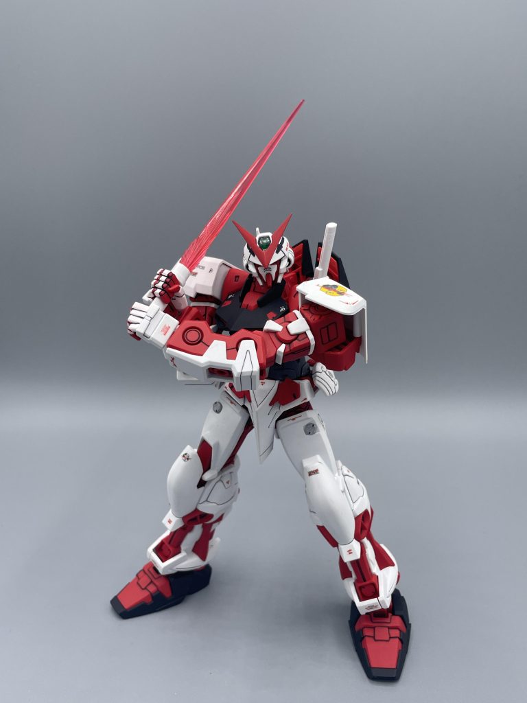 ビームサーベル   両手持ちも、当然可能。しかし、このキットの最大の弱点がこの画像にモロに出てしまっています。その弱点とはズバリ、”開脚範囲の狭さ”です。  足を開いた際の接地性が悪く、ギリギリまで開いてもこれが限界です。もう少し足が開いたら、こうしたポーズもカッコよく決まるので、少し惜しいところ。　ビームサーベルの造形がアストレイ系は独特で、高出力感を演出するためか、ビームの根本にギザギザが造形されています。シンプルにカッコいいです。しかし、パイロットのロウ・ギュールは機体のエネルギーを節約するため、ビームサーベルを積極的に使用しませんでした。それゆえ、レッドフレームのメイン武装は・・・・