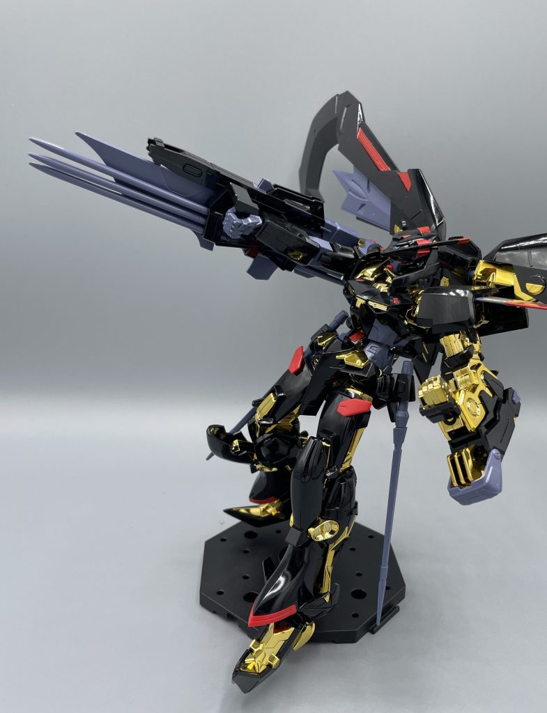 攻盾システム（トリケロス改）　あれ…なんか見覚えが。。。そう、ぶった切られてオーブ近海に落ちていたブリッツガンダムの右腕を拾って改良、くっつけたものです。　アストレイの特徴はゴールドフレームに限らず、徹底的に軽量化して機動性を確保するという、“当たらなければどうということはない” を地で行くトンデモ機体です。そのため、フェイズシフト装甲なんて贅沢品は、この貴族の機体にも装備されていません。しかし、拾ったブリッツ腕をくっつけているので、“右腕だけはフェイズシフト装甲” というちょっと面白いことになっています。　また、ブリッツの右腕に隠されたミラージュ・コロイド技術を解析したことで、全身にミラージュコロイド技術をまとうことに成功しています。ミラージュコロイドとは、機体に磁場でミラコロ粒子をくっつけることで透明になる迷彩技術です。そのミラコロ粒子が、黒地の方が吸着率がアップするらしいです。サフみたいなもんですかね。そのため、ゴールドフレームの装甲は白→黒に変更されたという訳です。決して中二病をこじらせたわけではないのだ。　そして、このトリケロス改はあのレッドフレームのガーベラストレートを叩き折る活躍を見せます。ギナは、ロウの振るうガーベラストレートを二本の指でピッと受け止めてから、トリケロスで叩き折ります。まさかの神谷活心流・奥義の極！刃断！w 明神弥彦か君はｗｗ　しかし、その後ブルーフレームの登場によって戦局が一変し、ブリッツの腕は再び・・・。