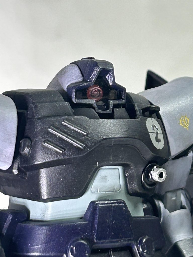 伊達にドムのキットにハズレ無しと言われていない、と感じざる得なかった為大きな改造はせずに気のなった点をちょいちょい手を加えていきました。イタズラにディテールを増やすのではなく、基本的にビームバズーカのディテール量に併せたディテール量になるように、と言う事を念頭に置きました。……近いと筆ムラ目立つなぁ。頭部は一番手を加えたかと。キットのままだと頭頂部がちょっと立体的な印象を覚えた為、下面を(おそらく)1ミリ削って少し潰れ気味に。モノアイカバーの頂点、十字の上を0.3のプラ板で一部を囲って&頭頂部に半円の1ミリプラ棒でディテールアップ。それに加えて面取りの角度と大きさを変更。モノアイにジェルシール&それに合わせて基部の小型化。そうすると内部フレームに干渉する場所ができてくるのでレール部分を切除。胴体はプラ棒でディテールアップメインで。武装を変更した関係でヒートサーベルの取り付けジョイントは適当に埋めました。左胸の拡散ビーム砲は、個人的に有用性を見出せない為に銃身をでっち上げて機関砲にしました。脳内設定ではコレはアヴェンジャー(実在の攻撃機A-10に装着されているもの)……個人的にガンダム世界の機銃の口径デカ過ぎだと思うのです。