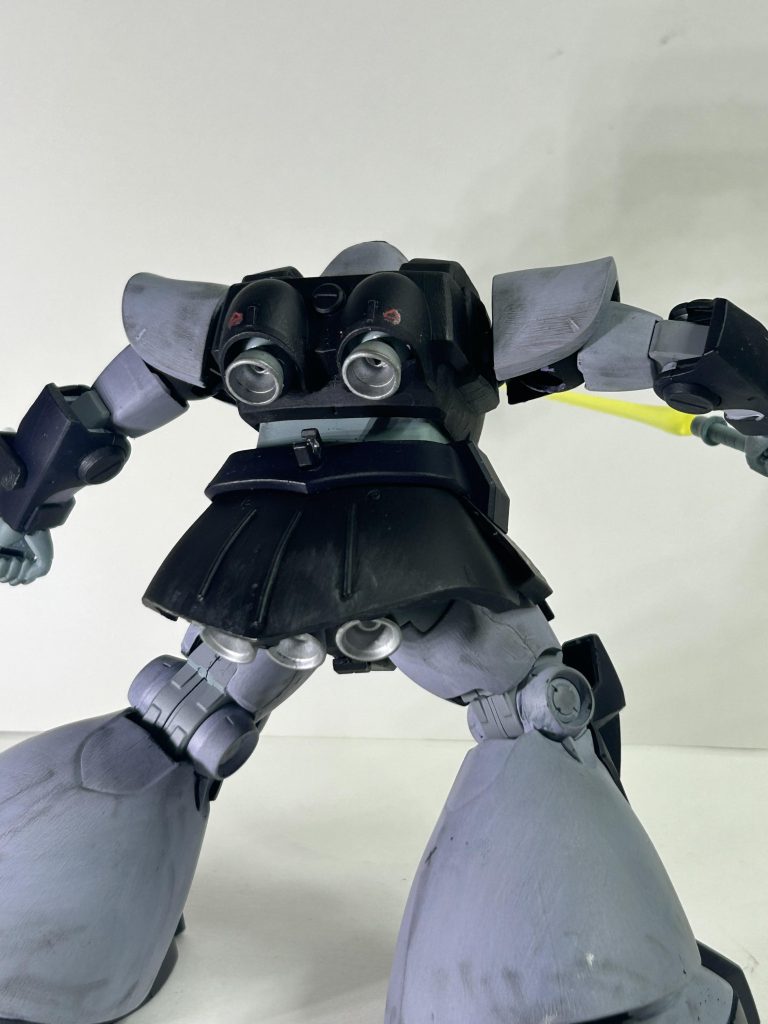 腕は、ほぼストレート。だけど、手首から先をグフのものに変更、それに合わせて手首基部を他キットから移植。理由としては、ドムの手は出来が良く表情豊かであるものの大きめのサイズ。アニメ的には正しいものの、リアル寄りにするとオーバーサイズと感じる為です。あとは左腕にはゲルググの盾を装備させたかったから3ミリドリルで雑に開口。腰は、表面がのっぺりした印象なので、プラ板とジャンクパーツ、半円プラ棒でディテールを入れ過ぎない程度に情報を増やしました。スカート後部のプラ棒のディテールはF-2戦闘機のノーズ部分のイメージです。キットのままではスカート内のバーニアが奥まった位置にある為、取り付け位置を変更しました。あと、ゲルググから持ってきたビームナギナタを取り付けることができるようにジョイントを付けました。