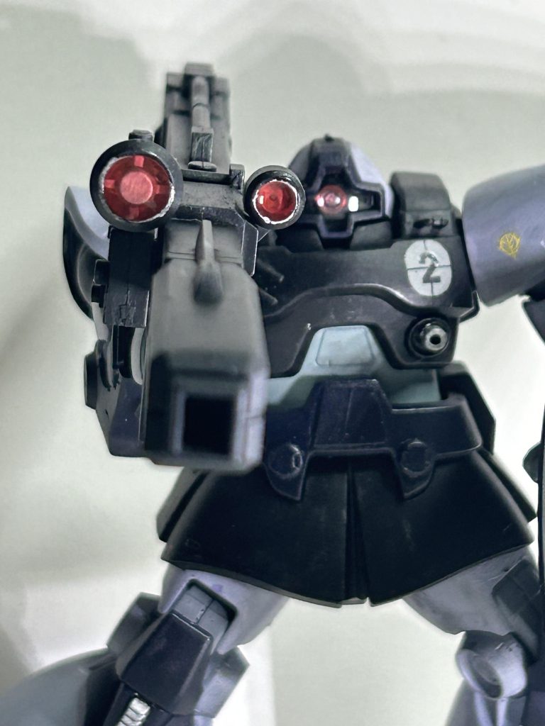 武装には、付属のビームバズーカに加え、ビームナギナタとシールドを選択。選択の理由としては、ビームバズーカ→リックドムだから。本当はゲルググのライフルを装備して、対MS戦能力を高めた〜、ってしたかったケド、我が家のマウンテンサイクルから発掘出来ませんでした。レンズはクリアレジンで作成です。ビームナギナタ→ヒートサーベルがあまり好きで無い為。拡散ビーム砲をオミットした為、ジェネレータに余裕ができビーム兵器の二本持ちが可能となった……と言う設定。シールド→ゲルググのシールドを装着できるようにジャンクパーツで適当にシールド基部をでっちあげました。装備させた理由としては、ドムは重MSと言われるが脚部のホバーを装備したのが原因だ……みたいな記述が小説だか解説本だかで読んだ覚えがあった気がする為ですね。他のジオンのMSと対して耐久力は変わらないとすればシールドを装備するのも不思議でないはず……と言いつつも左手が完全フリーなのが気になったのが一番大きな理由だったり。