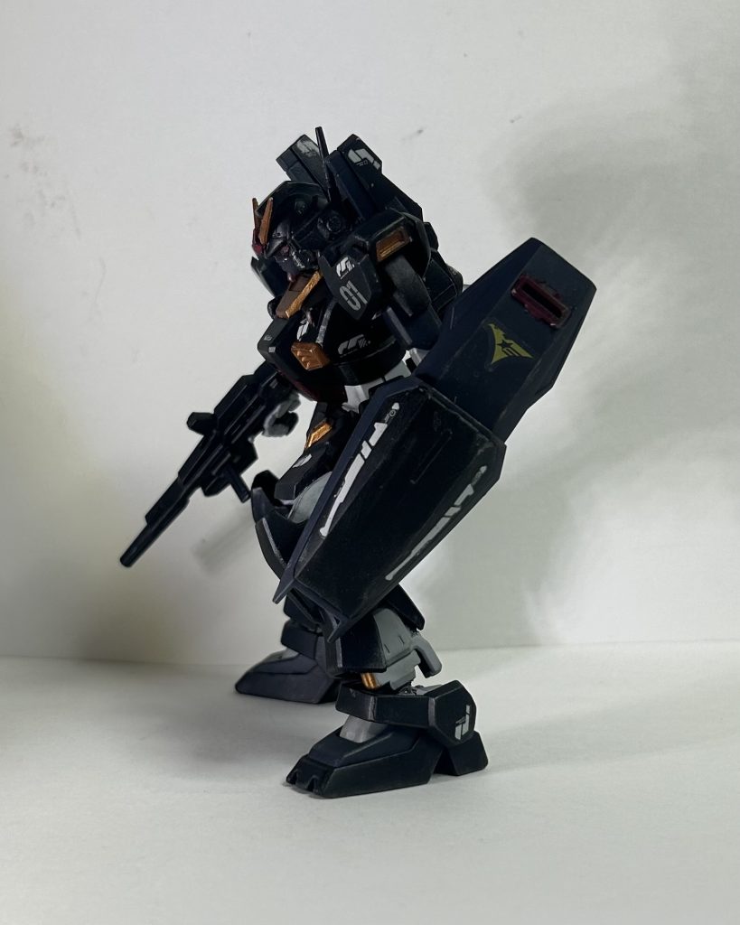 塗装は前回のドム同様、アクリルガッシュで塗装です。悩んだ末にティターンズ風なカラーリングにしました。他の候補はオリーブドラブ系で塗って陸戦仕様orコマンドカラーでした。関節、フレーム部分、下地にグレーサフ。あとはひたすら筆塗り。今回はアクリルメディウムを気持ち多めに。黒いガンダムって言うのがMkⅡの触れ込みだからティターンズブルー的な色にはせずに黒で。一応黒は3種類、1-青を混ぜた黒寄りのグレー、2-それを黒を混ぜて更に黒に寄せた黒、3-少し赤を混ぜた黒……よくわかんねぇなコレ!一応数字で使った場所を示すと1-フェイス、二の腕、手の甲、太腿、足の甲、ビームサーベル2-胴体、腰アーマー、肩、前腕、下腿3-バックパック、腰のワンポイント、バルカンポッド、ビームライフル、スリッパとなっています。コクピットブロック等は沈んだ感じの赤。アンテナ等の金はシタデルカラーで。バーニアはガイアカラーのシルバー。