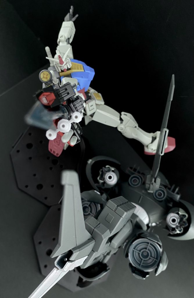 「あわせろよ！サメ野郎っ！」　感嘆するより他なかった。見事な動き。水中用MSにも引けを取らない機動性能を持つのか？ガンダムという機体は。ただ、それを言うならば相手のゴッグもまた、かなりのものだ。こちらからの攻撃がことごとく回避される。一対二であるにも関わらず互いに有効打を与えることが出来ずにいる。「やるなワニ頭の分際で！…こっちは二対一だぞっ！」　見事な動きだが、ガンダムのパイロットの焦りが伝わってくる。だんだんと戦闘域がプラント側に寄って来ているのだ。「いい加減こっちも弾切れだ。…いいぜ、お望み通り接近戦でカタをつけてやる」　そう言ってガンダムは、持っていたビームライフルから大きな「銛」を引き抜くと構える。「いいか、サメ野郎！ワニ頭を挟み込むっ、タイミングを合わせろよ！」　言うが否や、ガンダムはしなやかな泳ぎで、ゴッグ？の右側に回り込んでいく。自分は左側だ。と機体を反転させた瞬間にアラート。警告音が鳴る。メインモニター脇に表示させていたマップを見ると、自分達がすでに油田プラント群に入っているのがわかる。