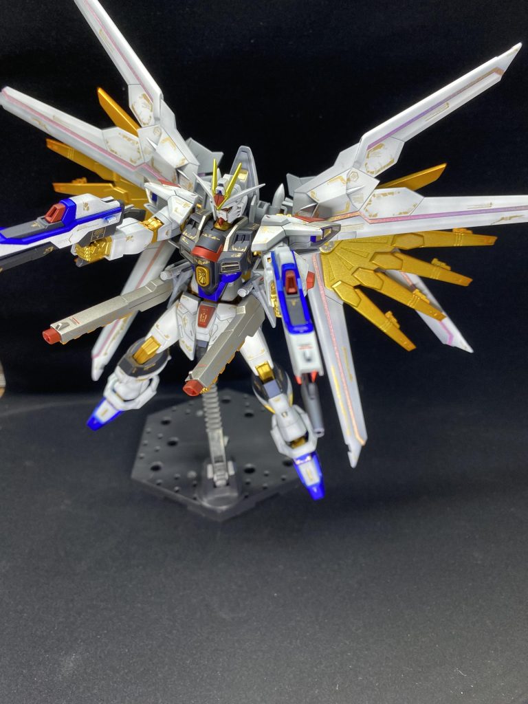 下地はサーフェンサーevoブラック白部分、クールホワイトでグラデーション後クールホワイトとガイアノーツクリアで調色グレー部分、スターブライトジュラルミンゴールド部分、スターブライトゴールド（プラウドディフェンダーにクリアオレンジでグラデーション）赤部分、パールシルバーとプレミアムレッド青部分、パールシルバーとウルトラマリンブルー黒部分、プリズムブルーブラック黄部分、スターブライトブラスプラウドディフェンダーのプラスチックシールにガンダムマーカーホロレッド