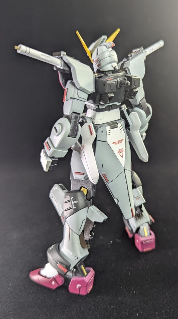 スタイル改修のポイントとして、私の作品の定番であるヘルメット前後1mmプラ板による延長。肩アーマーは軸に通す構造にし、前腕とは独立しています。胴体部分は2mmほど延長。脚部の関節も3mmほど延長しています（ちょうど写真では金色に見える部分）。ふくらはぎ部分のスラスターはプラ材でスクラッチし、ディテール増量しています。この他全身の小さいプラ材を貼り付けてディテールアップしています。スジボリはやや控えめとしました。