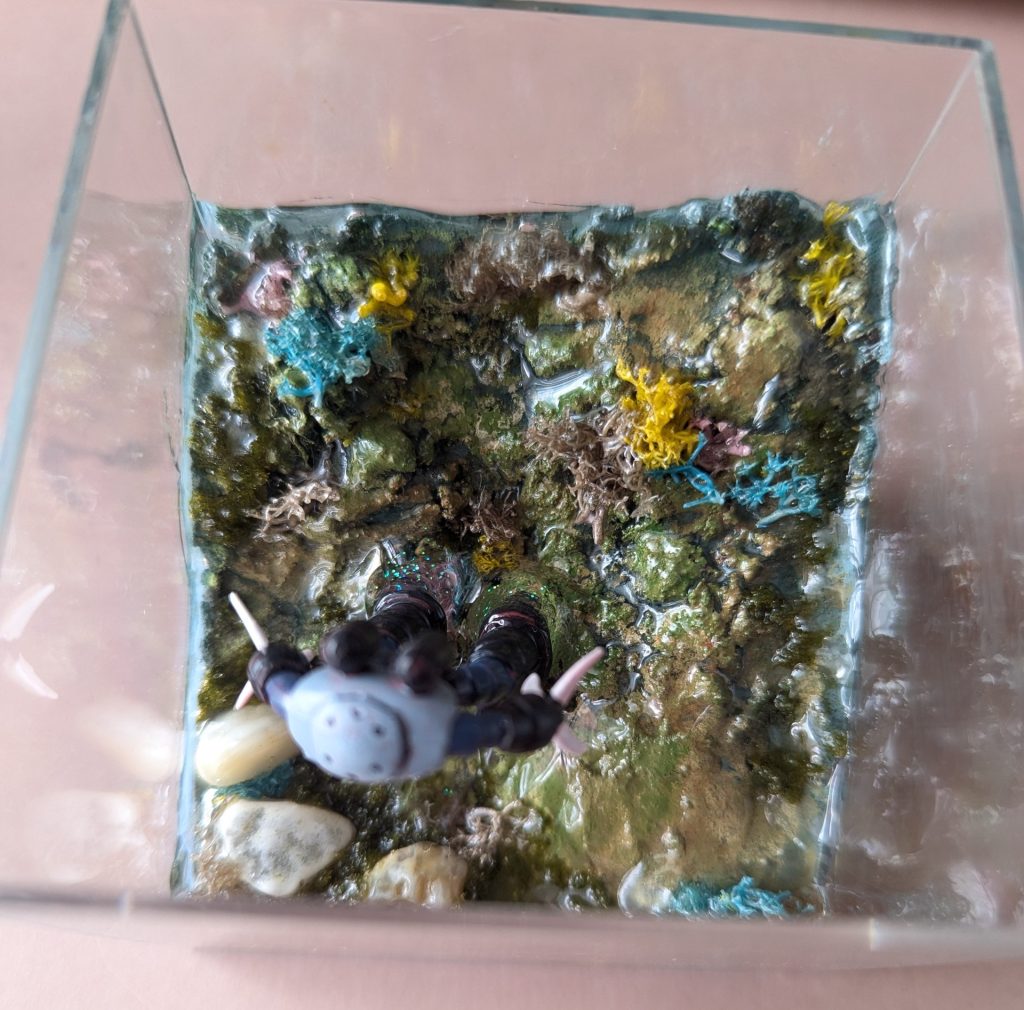 絶対気泡ぶくぶくになるから…と思いUVレジンでコーティングしつつ、ズゴックもUVレジンで固定していきます。 その後子どもの工作のあまりのエポキシレジンで埋めたのですが…