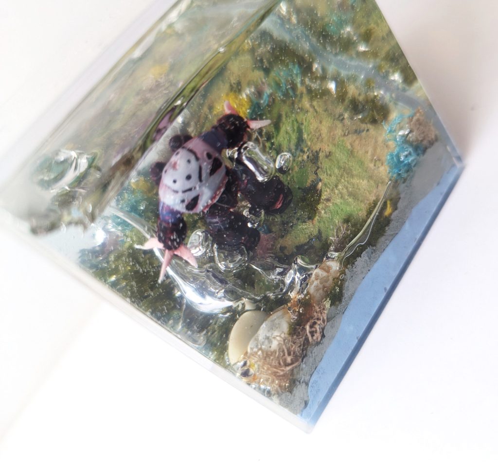 UVレジンでの接着が甘かったのか土台から気泡。外気温(36度)とレジンの硬化の熱さでズゴックの塗装は剥げかけ、爪が若干歪み…あぁぁぁぁと思いつつちょっと目を離した5分くらいの間に気泡が広がりブワァン!慌てて冷蔵庫に入れて硬化したところこの程度で済みました_|\○_エポキシレジンで埋めるのはなかなか難しいですね~。