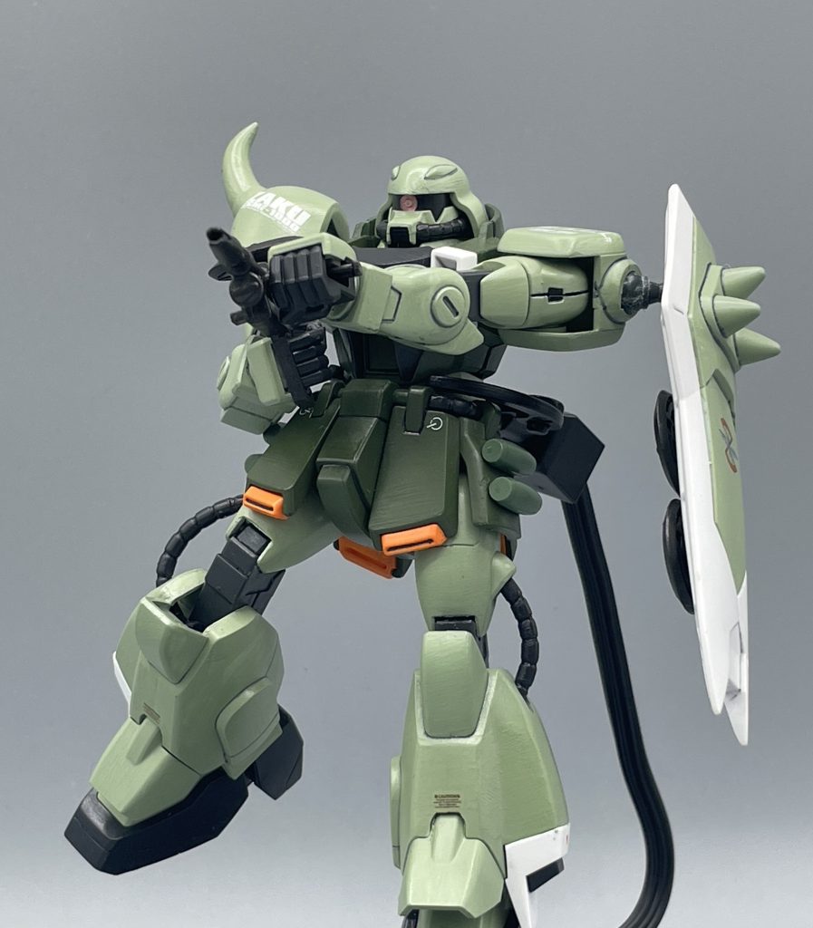 こんなところで、君を死なせる訳にいくか!!ところでZAKUとは一体・・・・ZaftArmedKeeper  ofUnity の略称となっており、「装甲に身を固めたザフト統一の守護者」を意味します。一応ちゃんと設定は練られていますね(笑) いつも思うのですが、この手の略語ってカッコ良くて好きだけど、「of」はどこ行ったねん!無くしてええんか⁉と思ってしまうのは、私だけでしょうか。 もちろん、初代「機動戦士ガンダム」に登場する伝説のMS・ザクをパクt・・オマージュした機体です。ザクもザクウォーリアも、どちらも大河原先生がデザインを手掛けられています。あれほど、MSとして完成しきったザクをリファインするのは、大先生と言えど、さぞ勇気がいったことでしょうね。 初代のザクはビームが使えませんでしたが、ザクウォーリアはビーム兵器の使用が可能であり、画像で構えたライフルは、「MMI-M633ビーム突撃銃」と名付けられています。なにそのカッコいい名前。