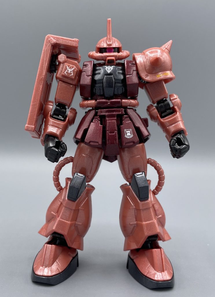 MS-06S シャア専用ザク  ある時、私は筆塗りでメタリックやキャンディー風の塗装に仕上げることに凝っていました。 (シャアザクも、テッカテカに出来ないかなー)と考えながら、日々を過ごしていました。 これが原色系の機体なら、何の問題もないのです。例えばサザビーなら、メタリックレッド→クリアレッド→光沢スプレーと塗装を重ねていけばOKです。ただ、いかに赤い彗星といえども、その手順で塗ってしまうと、出来上がるのは“ジョニー・ライデン感満載のザク”になってしまうんです。 シャアピンクとも呼ばれる、淡いサーモンピンクのメタリックやクリアの塗料なんて売っていません。