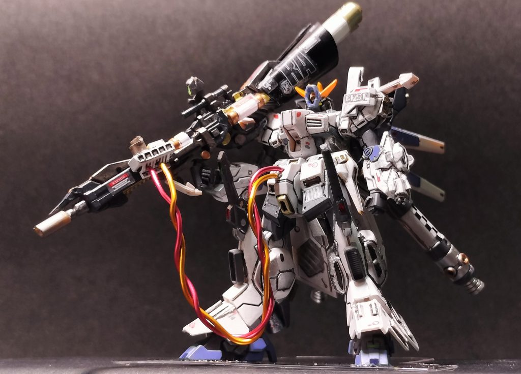 ６.        一方、敵機に肉薄された際の装備も用意されている。左腕には実体弾のガトリング砲と試験型ビームバリアが装備された。頭部のハイメガ粒子砲の発射時の衝撃で一般のブレードアンテナでは折れてしまうので、頑丈で折れないプレート（ plate）アンテナが装着されている。