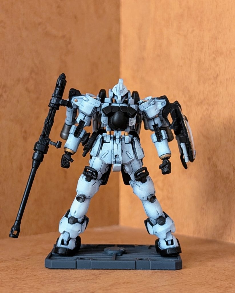 型式番号:EMS-10L機体名:ヅダL武装:ビームサーベル、専用対艦砲「ドーバーガン」、スローインボム、ラウンドシールド特徴:ジオン公国軍の制式MS採用試験において、ジオニック社のザクⅠに敗れたツィマット社のヅダを元として、一年戦争末期に開発されたヅダの強化改良型。大推力を短時間で獲得しつつ、推進方向を自在に転換するなど、宇宙空間で高い機動性を誇っていたヅダの機体特性をさらに改善し、最大の問題であった「土星エンジン」の安定化もリミッター強化によって成功している。機体の一部には高機動型ザクⅡとゲルググのパーツが流用されるなど、いかにも戦中の物資不足の中で開発された機体らしい面を持ちつつも、背部には可動式大出力バーニア「スーパーバーニア」が2基増設され、ヅダの特徴である機動性能をさらに高めつつ、様々な改良が施され総合性能自体が向上した。ジェネレータ出力も向上しておりジオン軍のMSとしては最初期にビームサーベルを採用したため白兵戦能力も高い。その他の武装としては専用対艦砲「ドーバーガン」と右のサイドアーマーに手投式爆弾の「スローインボム」を備える。しかし高機動を追求しすぎたため、一方で機体をフルスロットルにした場合直線機動で15G以上まで達するためパイロットに『殺人的な加速』による文字通り全身の骨を砕き死に至り兼ねない、並の人間には扱えない機体となってしまった。パイロット:ミリアリア=ゼウス二級特佐20歳。ジオン軍のスーパーエース。「ライトニングバロネス」と「白い稲妻」の異名を持つ凄腕の女パイロット。女性としては長身で金髪のロングヘアーという誰もが振り向きそうな出で立ちだが、常に仮面を被っているため素顔を見た物は誰一人としていない。本人いわく顔に酷い火傷を負っているらしいが……。自身の要求するMSの制作に必要な「ヅダ」を受領するため、単身グワジンに赴く。