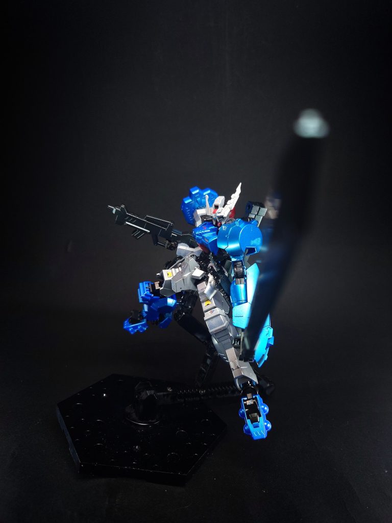 武装・必殺攻撃  デモリッション・ナイフ本機が背中にマウントしているメイン武装で折り畳み式の大型剣。振り下ろしながら刀身を伸長することで、敵の予想を上回る間合いからの攻撃が可能となる。しかし、2つ折り故に刀身に可動部が存在し、純粋な強度としてはあまり高い訳ではないので収納状態から柄のみを出して使うこともしばしば。