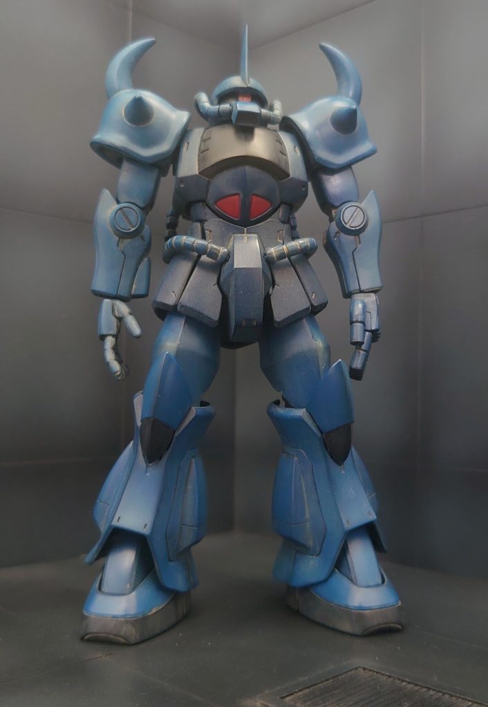 初めまして。象の目と申します。数年に1度ガンプラ熱が過熱するモデラーです。今回は人生初めての製作依頼でHGグフを組ませていただきました。こちらのサイトは前から拝見していたので依頼主の許可を得て投稿しております。投稿に関して少しストーリーを付けていきたいなという事で整備兵のぼやきを添えてみました。依頼主様からの要望は「砂漠戦のグフ」ということでしたのでウェザリングはそれを意識してあります。また腹部オレンジの部分はキットではクリアパーツですが今回の製作では塗りつぶしてあります。ボディの色はテレビ初登場の時の少し暗めのブルーをイメージしています。全色わかるかわからないかの量のシルバーを混ぜているため光の加減では少しメタリック感が出ます。