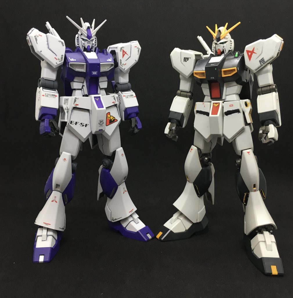 過去作のHGUCキットと(実際にはHWSの素体)。色分けも可動も進化していますね。ただヘルメットの1パーツ抜きでの整形などHGUCから継承されているところもありました。このために取り出したら関節がABSの頃のものなのでギッチギチになっていました... 塗装は水性ホビーカラー中心です。前回投稿のダガーLのように色変え部分やHGBC系パーツなどのグレー部は水性ホビーカラーの筆塗りで仕上げています。部分的に色変えするときでも水性ホビーカラーは使いやすいですね。 色合いはヴレイブが普通なら青なのですが、今回はHi-νガンダムVer.kaのように紫にアレンジしています。紫=水性ホビーカラー パープルグレー=同ダークグレー(フィールドグレー1)本体部銀=ガンダムマーカー シャインシルバー関節部銀=同メッキシルバー赤=同レッド 塗装後はRG νガンダム用のデカールから装甲のエッジに沿ったラインマークを一部の注意書きを貼っています。また連邦やロンド・ベル、アムロのパーソナルマークを貼っていますがこれは単に趣味です。どうしても逆シャア用のデカールが貼りたくて...ビルドシリーズの世界では貼ってないという設定で許してください.... 関節が異常なまでに緩くなっていたので撮影時には足や肩が勝手に垂れてきてストレスフルなことこの上なく...撮影終了後にパーマネットマットバーニッシュを塗って関節の調整中です。