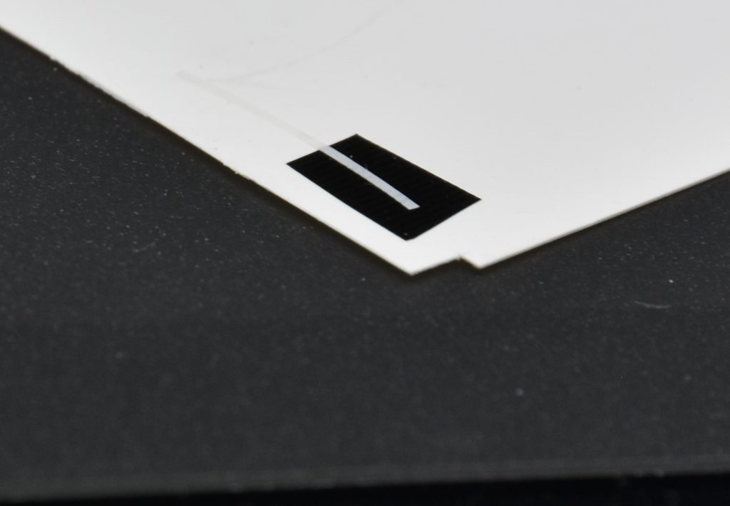 カットしたフィニッシュをプラペーパーの上に貼り付けます。直接パーツに貼ると歪む恐れがあります。上からキット付属のシールを張り付け、同じ形状に切り出します。最後に付属のシールを剥がしてインテーク内に貼り付けます。