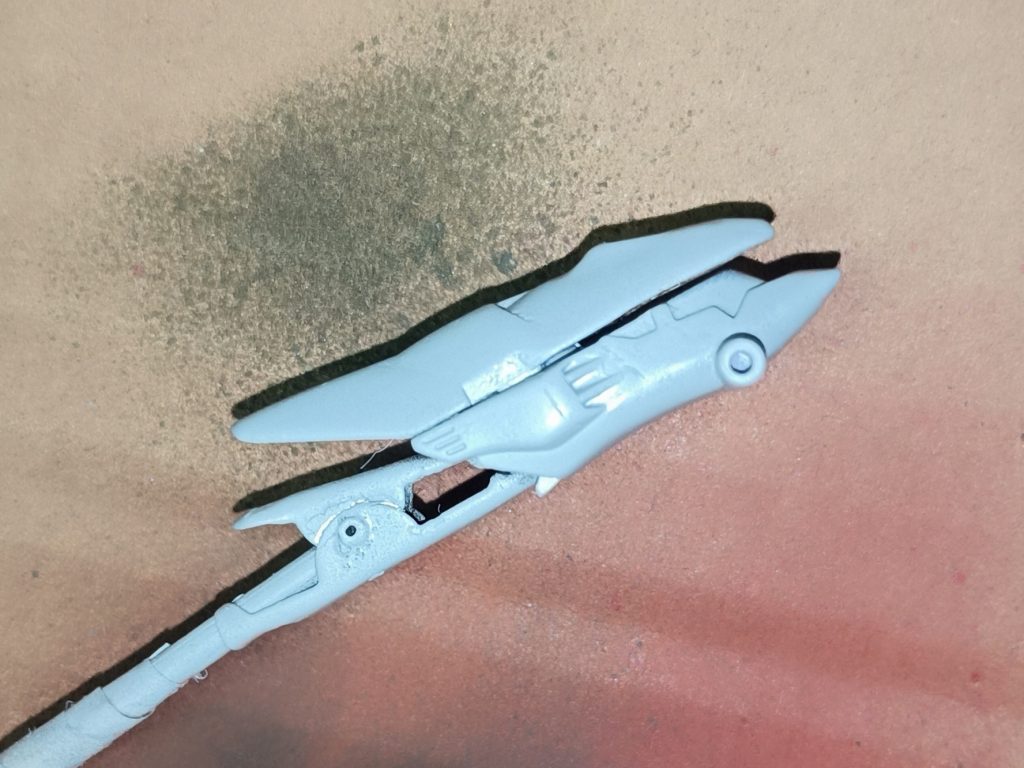 仮組みの際、どうにも愛嬌がありすぎるように感じたのでヒサシを延長。良い感じな悪い顔になってくれました。この時頭部センサーがパテで埋まってしまいそうだったので、コトブキヤのディティールアップパーツから丁度いい形の物を選んで埋め込みました。この延長工作ですが、ヤスリを掛けすぎて画像のように上下のパーツの隙間がガバガバどころかスカスカになってしまったのでプラ板を挟んで解決を図りました。上手く行った……はず。