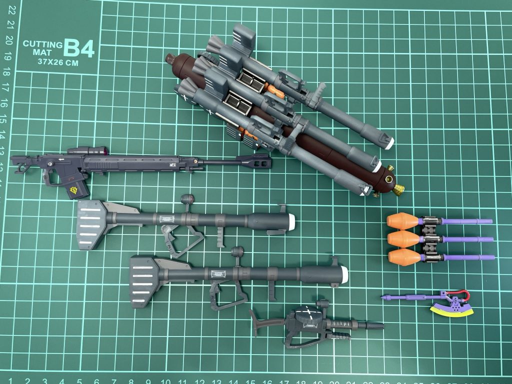 武装一式ザクバズーカ3本、ジャイアントバズ2本、シュツルムファウスト4本(もう一本予備アリ)、ザクマシンガン、ヒートホーク、予備弾倉、対艦ライフル(オリジンシャアザクより拝借)です。ヒートホークは、旧キット風にパープル系で柄の部分を塗り、刃の部分は蛍光イエローで塗装したのち、クリアイエローを刃先に薄っすら乗せています。シュツルムファウストの柄の部分もパープル系、頭の部分はオレンジ系としました。