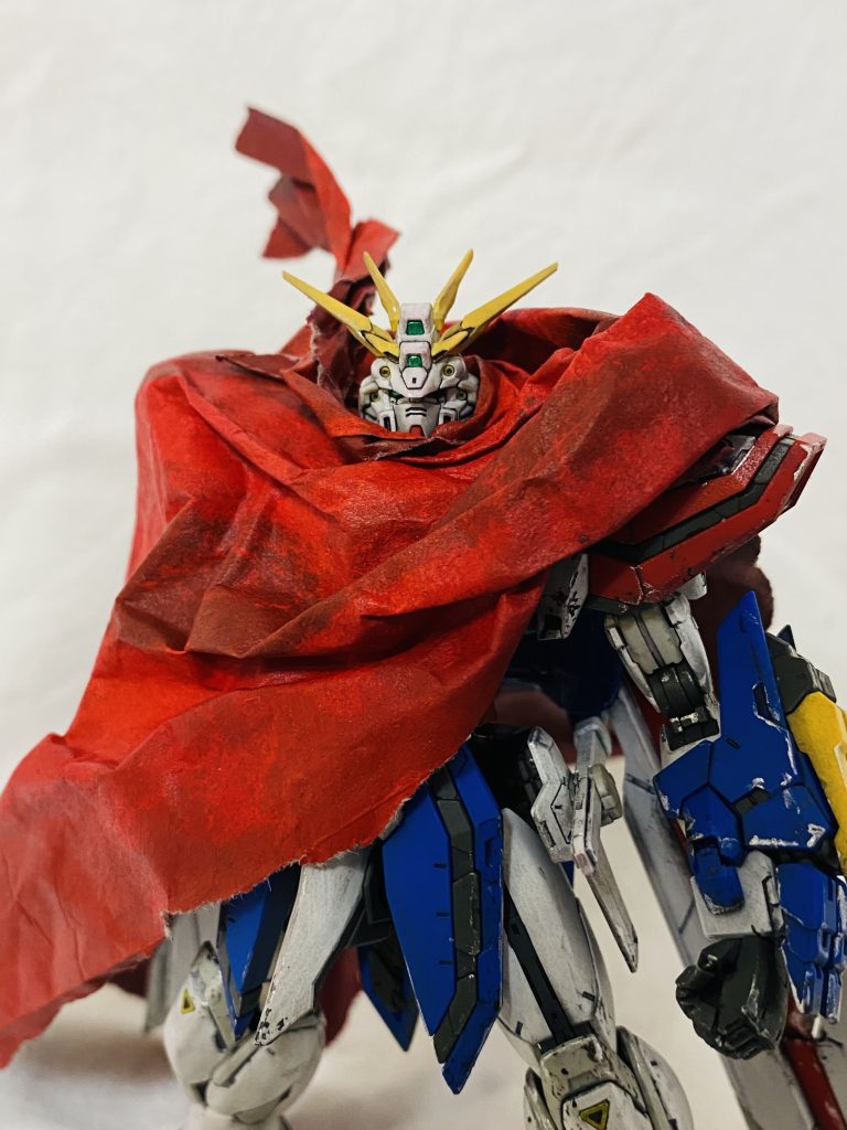 緩衝材で使う紙にアクリルで着彩しました。イメージとしては、ガンダムファイトを闘い抜いたゴッドガンダムが、ドモンと同じようにマントを羽織った姿です。