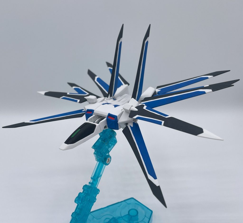 『ライジングストライカー』　ライフリのウイング動作や飛行形態の為のデータ取りや、プラウドディフェンダーの試作機として造られた支援機。有人での単独飛行・無線誘導による飛行の両方をこなす。粒子放出量の調節や、ストライク弐式との合体時の不具合を非常に微細なレベルで調整するために、過剰とも思える翼を有している。　准将とルル…ハインラインが弐式の推力不足を補うべく考案した。技術畑の二人は、オタク特有の早口で見る見る構想を練り上げていくが、それを聞いていた周囲のメカニックはこれから待ち受けるであろう膨大な数のトライ＆エラーに戦慄するのであった。