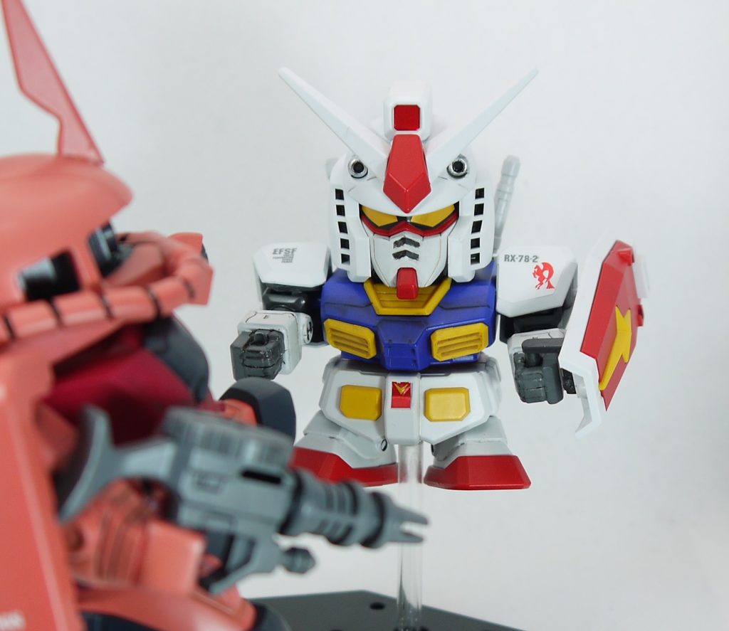 ガンダムの方は腹部を蹴られた状態を再現するため、プラ棒などを組み合わしてクサビ状のパーツを作り胴体と腰パーツの間に挟んでいます。ガンダムはほぼ成型色で色分けされていましたが、全塗装しました。 2体とも少しデカールを貼り、半光沢のトップコートを吹いて仕上げています。  あとは股の間に3mmのプラ棒を接続し、そこへ5mmのプラパイプをはめ込みます。プラパイプの方は100円ショップで買ったフィギュア用の台座に接着しました。