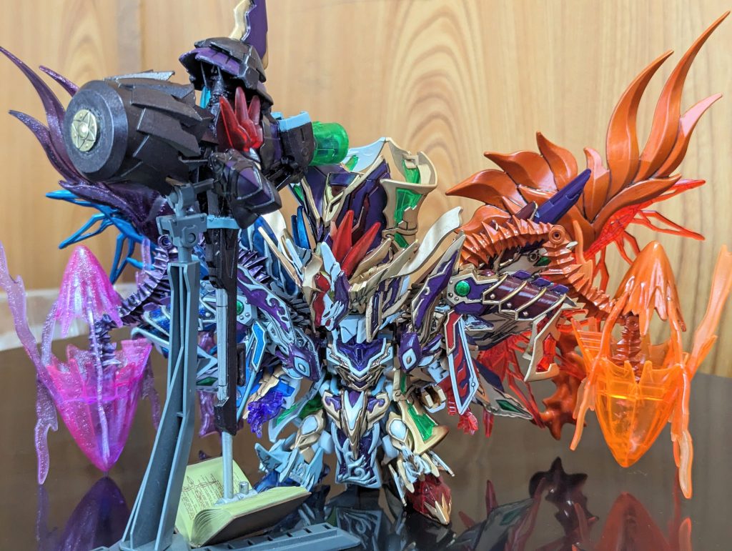 ストーリーに登場した閻魔大全という書物から出現した巨大なハンマーをイメージ。クシャトリヤの頭部と膝パーツ、ヘヴィウェポンユニット09 ボルテックスドライバーに入っているドリル状の部品を逆様に取り付けたモノ。持ち手はHGウイングガンダムのバスターライフルを加工してます。ストーリー内容は創世騎士 ビッグバンのページに記載。サンダルフォンの使う超振動とハンマーの組み合わせは絶大である。ちなみに下に置いてある本は魔法少女リリカルなのはに登場する八神はやての持つ魔導書をこっそり拝借 笑(小さな娘から物取っちゃいけませんw)