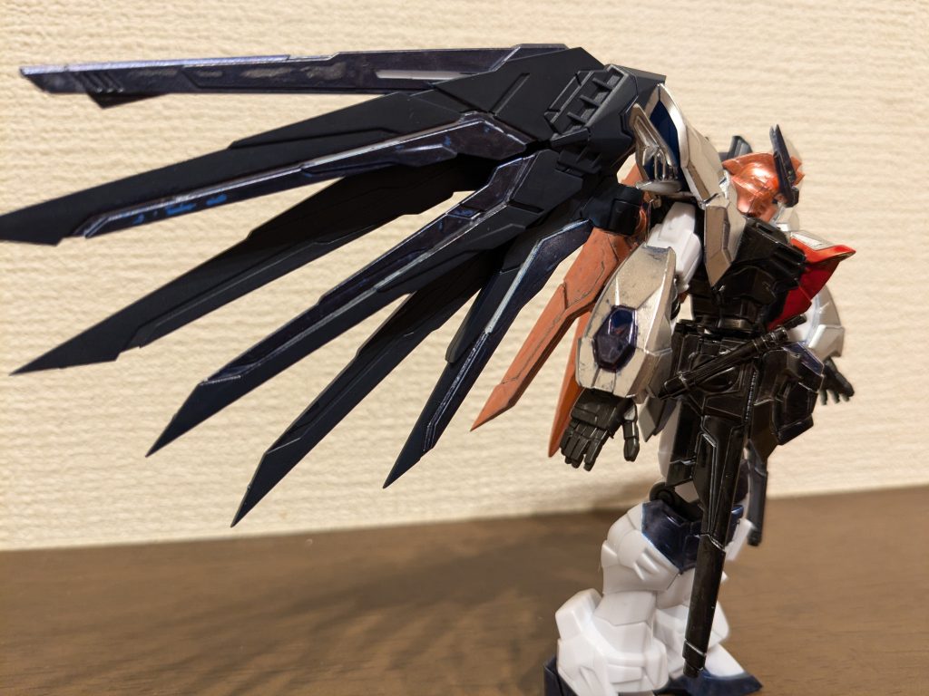 サイドショットできるだけ成型色そのまま、ガンダムマーカーのみ使用の部分塗装でいきたいと思って作成。頭部は髪をイメージしてメタリックレッドで、頭に付いている小さい羽のイメージでアンテナをメタリックダークブルーにしました。羽と脚も同じく、青と白の部分をメタリックダークブルーで塗装。肩、腕の青い部分はシャインシルバー、赤の部分はメタリックダークブルー。ボディは、肩、胸上部をシャインシルバー、残りとスカート全体をメタリックブラック、胸中央はネクタイイメージでレッドで塗装。