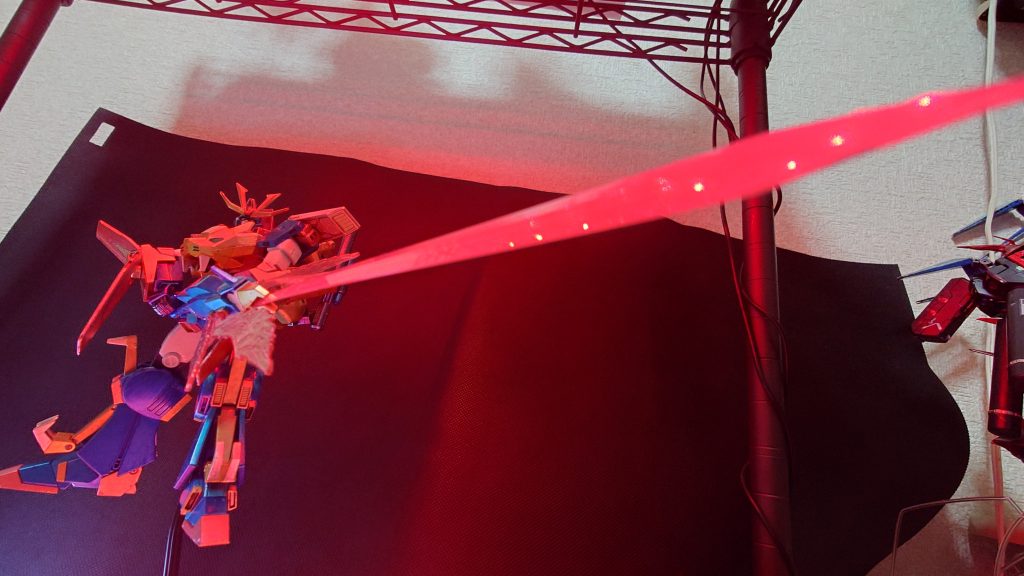 そして定番のサンライズ立ちカラーLEDを赤にして、下の台も赤セロハンをひいて剣のあたりを赤っぽく調整してみる超咆剣の柄の部分をスカート部分に挟んで支え抜きで無理矢理ポーズを取ってます。