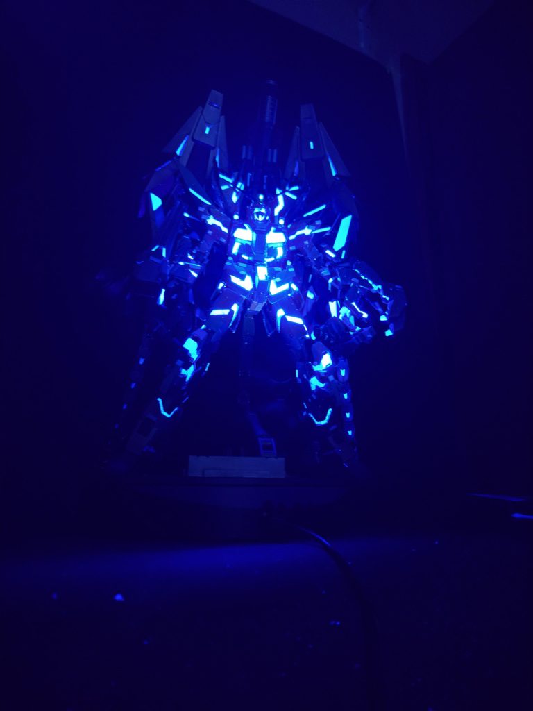 電気を消し、ブラックライトオンリーです。ボディに照射したところ、内なる光の発光ぽくなりました。気に入っています。サイコフレーム以外にもカメラアイ、各武器照準器、アームドアーマーDEのスタビライザー部にも蛍光塗料で部分塗装をしています。