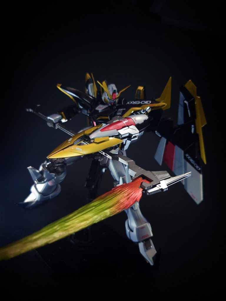 武装編集ビームサイズ巨大な鎌のような接近戦用ビーム兵器。一薙ぎで複数の敵機を撃破し、ビーム発生器の角度を変えることで槍としても使用可能[3]。ガンダムが装備するビーム兵器は、ガンダニュウム合金の採用によってデバイスの耐久度が向上するとともにビームと空間の間に電離領域と電磁界を発生させる特性を有しており[4]、水中でもいっさい減衰しないほどの高出力を発揮する[4]。非使用時は柄が短縮化し、腰部背面のラックに懸架される[3]。EW版では柄が杖のような非直線デザインに変更され、ビーム刃の角度調節機構及び柄の伸縮機構は存在しない。非使用時は短縮しないままバックパックに背負うように懸架される。