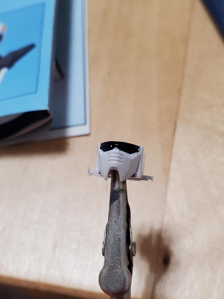 いよいよ顔へ!!ガンダムタイプの顔は、やはりツインアイが最大の特徴だわ。ツインアイとその周辺の塗り分けがうまく行くかどうかで全体の出来にも影響及ぼすほどじゃないかと思う。その点ジオン系のモノアイの方が楽だな。モノアイを別パーツで表現するように加工するのを考えても、ツインアイは両方を同じ様に塗らないといけないから、素人仕事だと誤魔化しがなかなか効きづらい…まずは周辺の黒塗り。